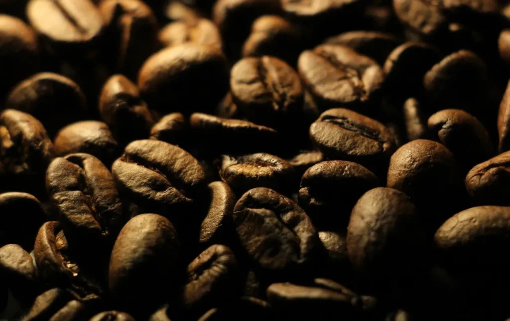 Cafeína en el deporte: cómo potenciar tu rendimiento y en qué deportes es más utilizada 1 Granos de cafe cafeina en el deporte beneficios